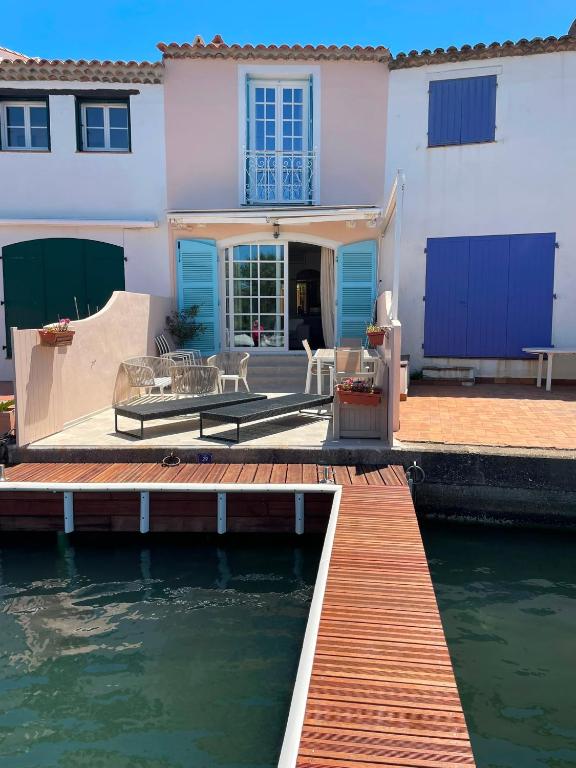 a house with a dock next to a body of water at Petite maison de pecheur in Grimaud