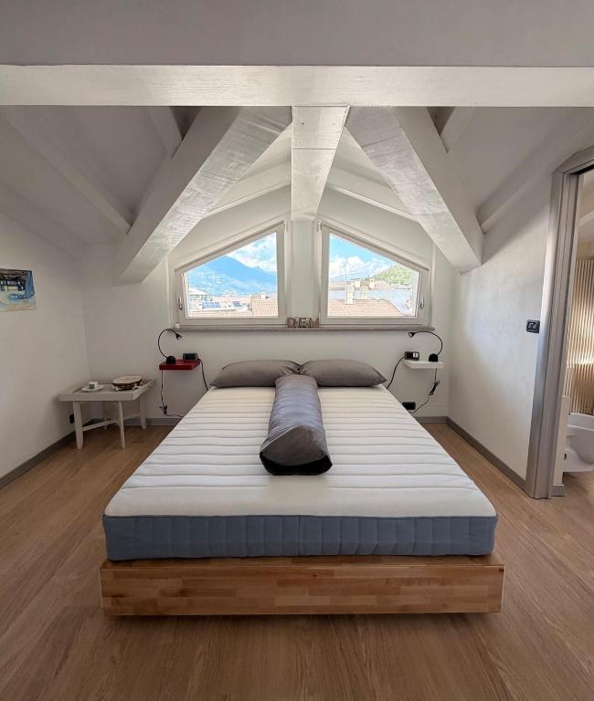 a large bed in a room with a large window at Casa Cocci in Aosta