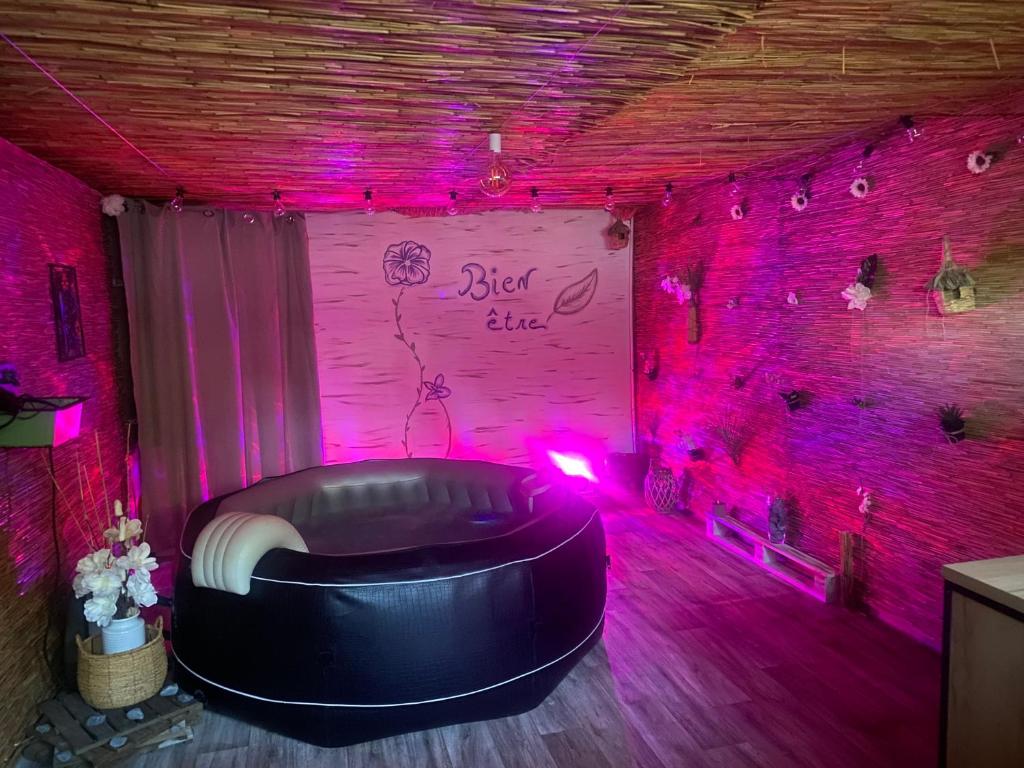 a room with a couch in a room with pink lights at Chez Aurele in Villersexel