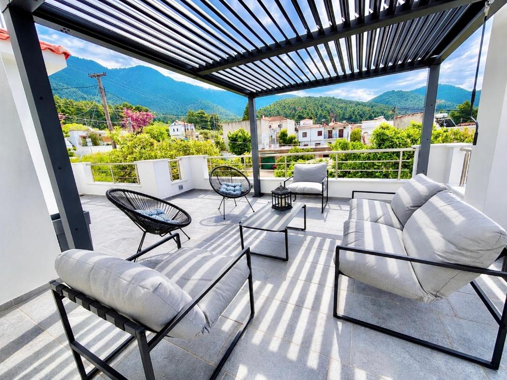 a patio with furniture and a view of mountains at Elios Serenity House in Neo Klima