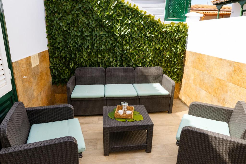 a patio with a couch and chairs and a table at La Casita del Sur, Abades in Abades
