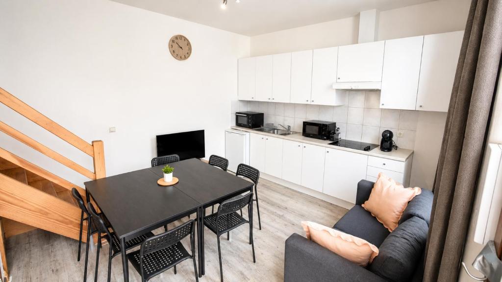 a kitchen and dining room with a table and chairs at Mons 21C in Mons