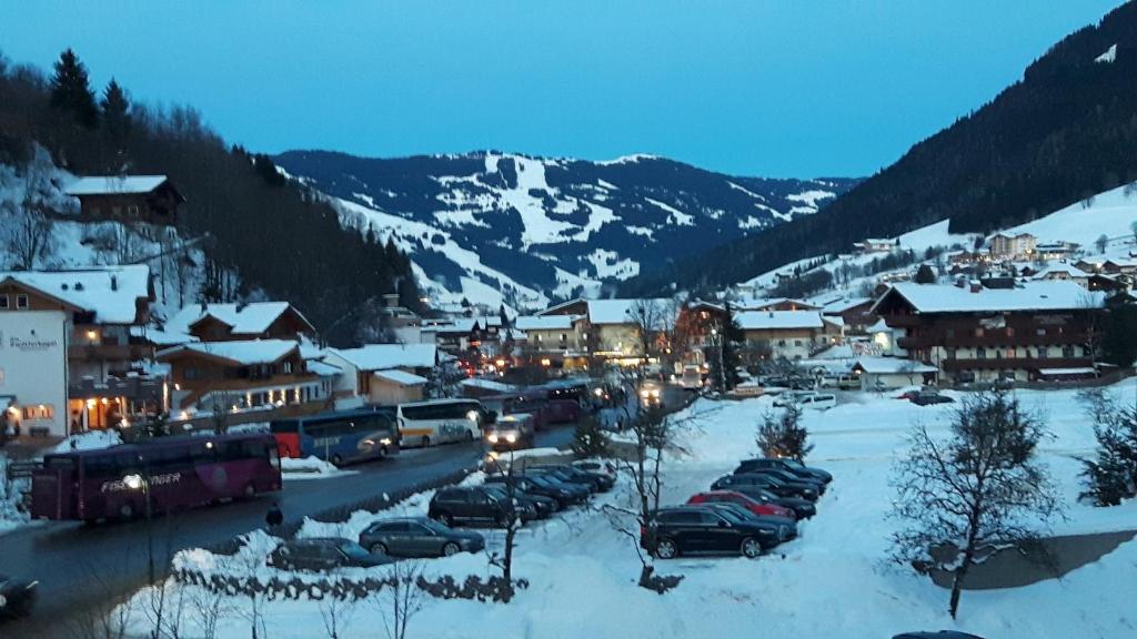 eine Kleinstadt mit Autos im Schnee in der Unterkunft Familienappartement Talblick include Jokercard - only summer in Saalbach-Hinterglemm