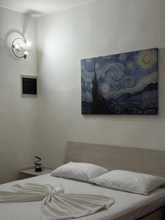 a bedroom with a bed with a painting on the wall at Spazioso appartamento 2 in Tortona