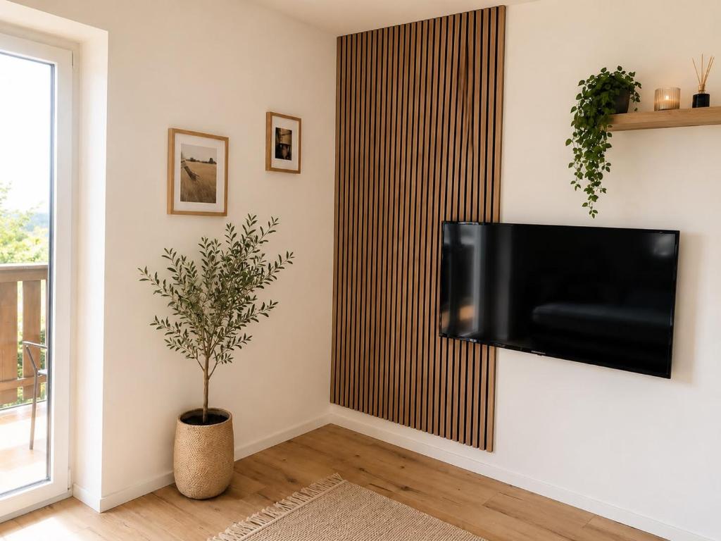 a living room with a flat screen tv on a wall at Apartment Torggl Alpenblick in Coldrano