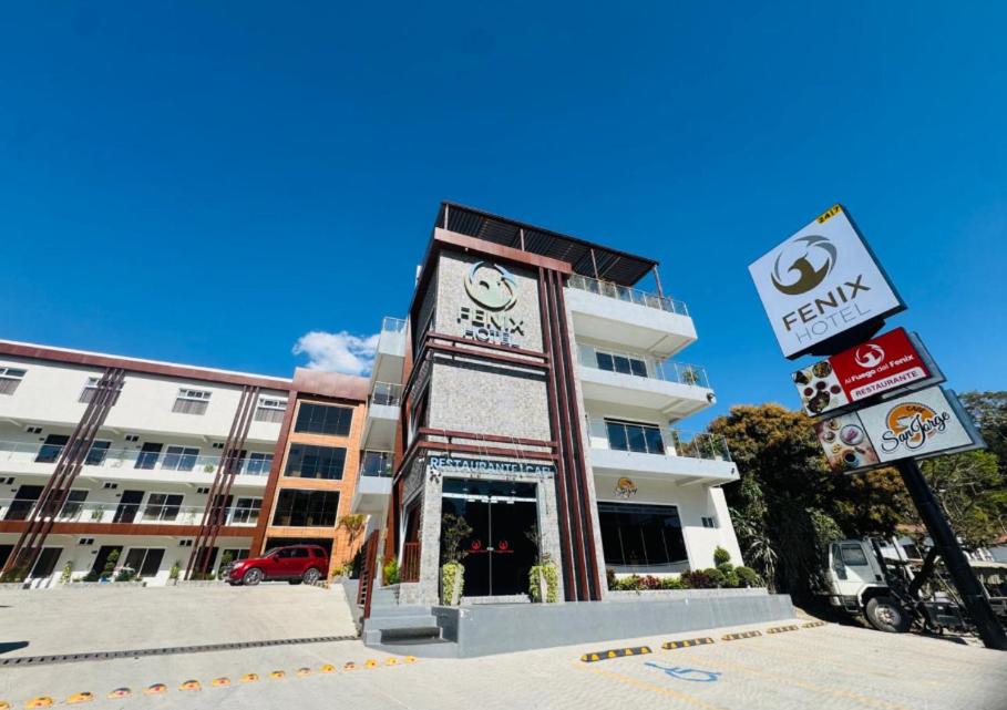 a building with a clock tower in front of it at Hotel Fénix in Santa Rosa de Copán