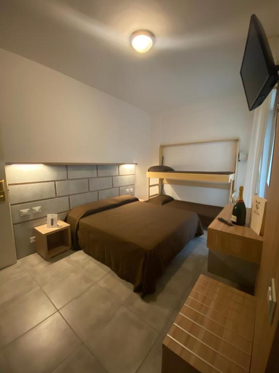 a bedroom with a bed and a flat screen tv at CASA MAJOR Hotel & Appartamenti CERVIA in Cervia