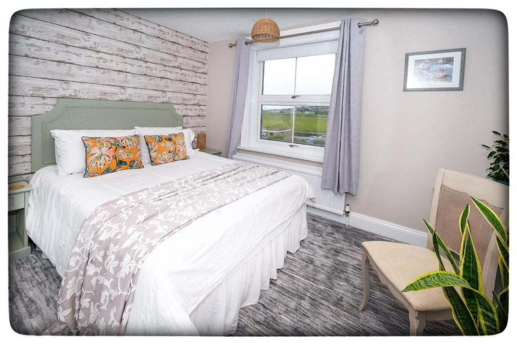 a bedroom with a large bed and a window at Britmead Guesthouse in West Bay