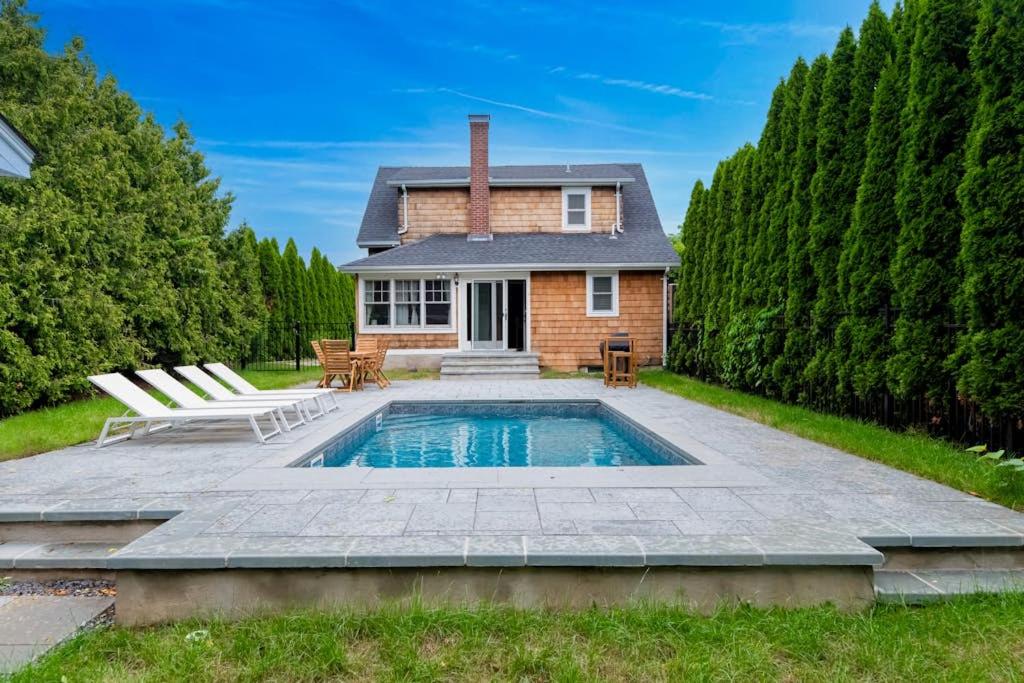 a house with a swimming pool in the backyard at Cozy Greenport Cottage in Greenport