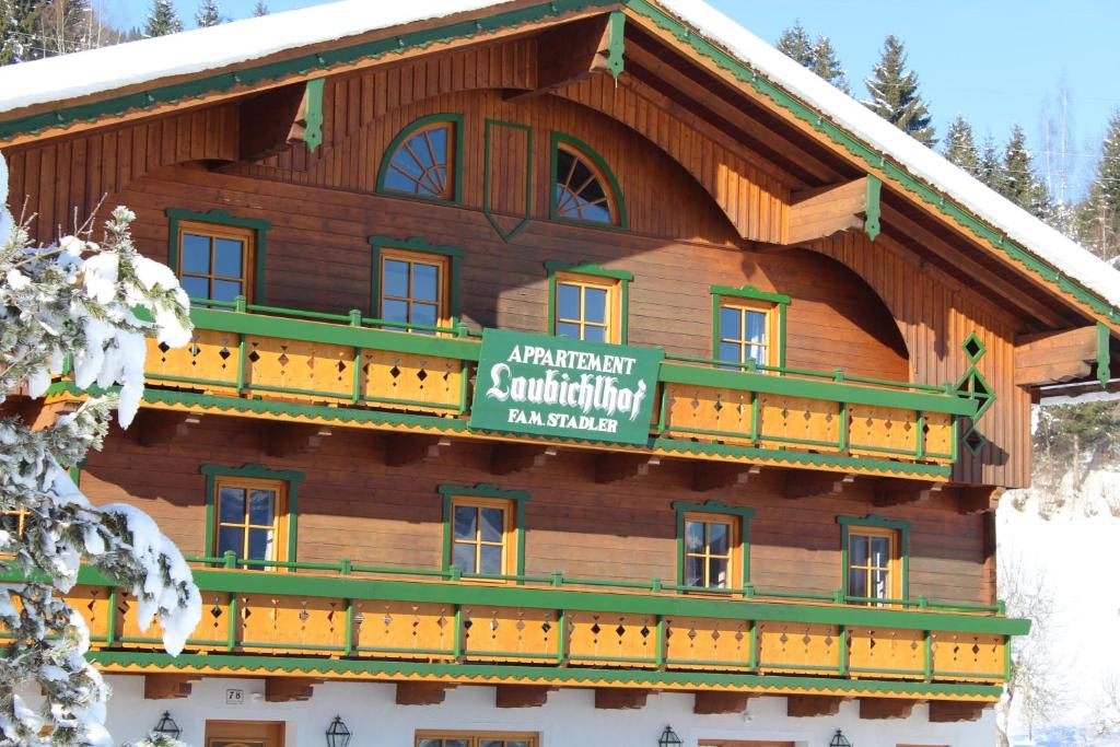 een groot houten gebouw met een bord erop bij Laubichlhof in Flachau