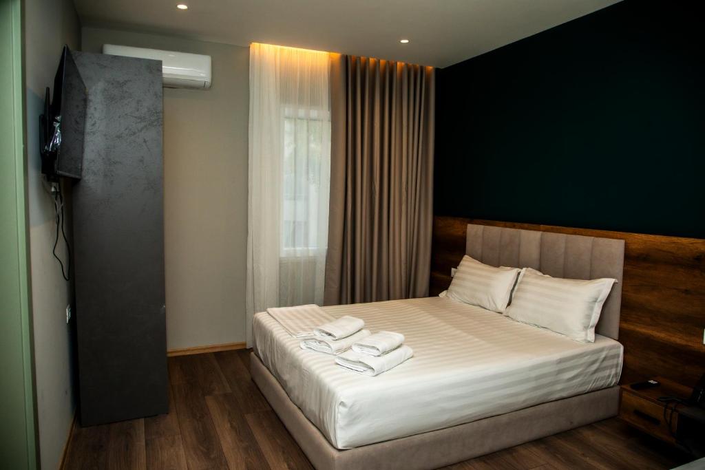 a bedroom with a bed with two towels on it at HOTEL CENTERPOINT Tirana in Tirana