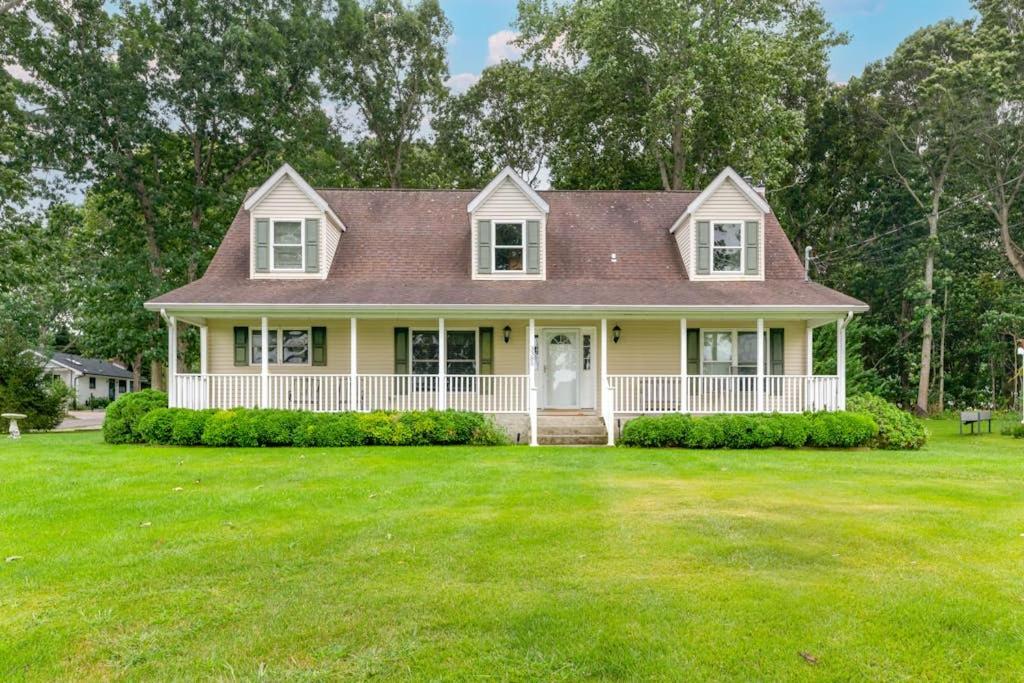 a yellow house with a large grass yard at Minnehaha Marvel in Southold