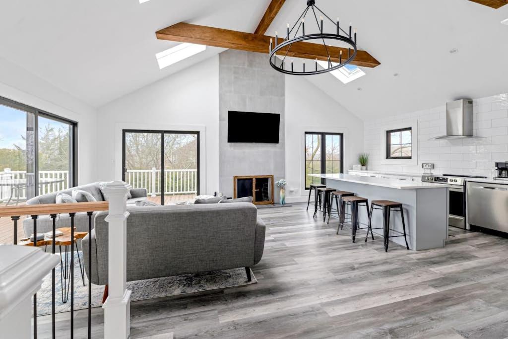 eine Küche und ein Wohnzimmer mit Sofa und Tisch in der Unterkunft Marble & Sun in Hampton Bays