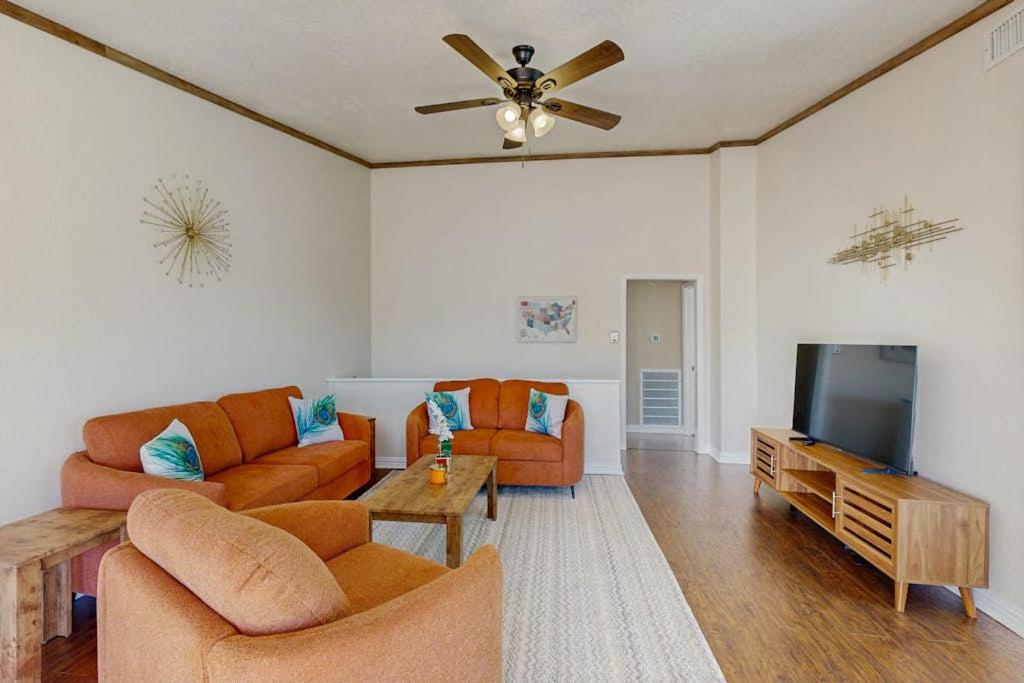 a living room with two couches and a flat screen tv at Waterfront Hideaway in La Marque