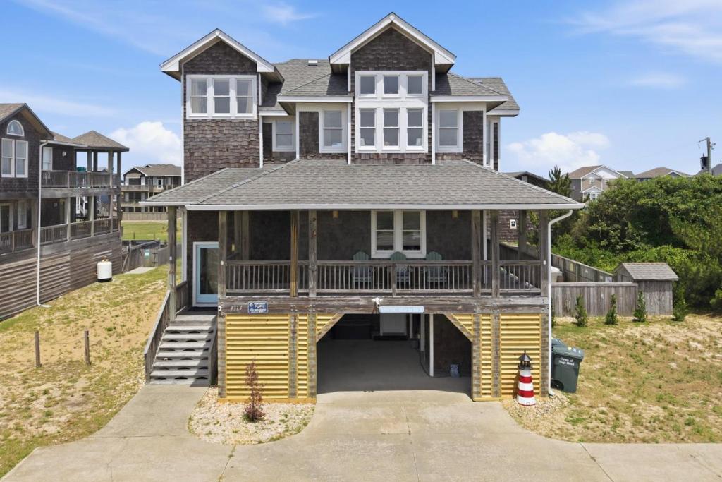 a large house with a porch and a driveway at 5471 - Resting Beach Face in Nags Head
