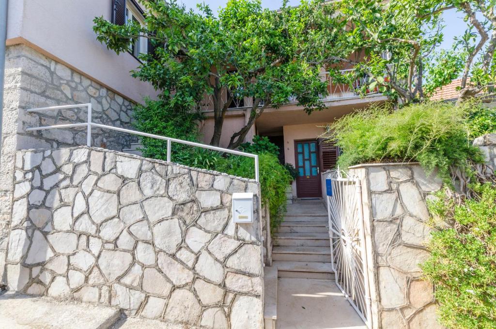 a staircase leading to a house with a stone wall at Rooms Roza in Vrboska