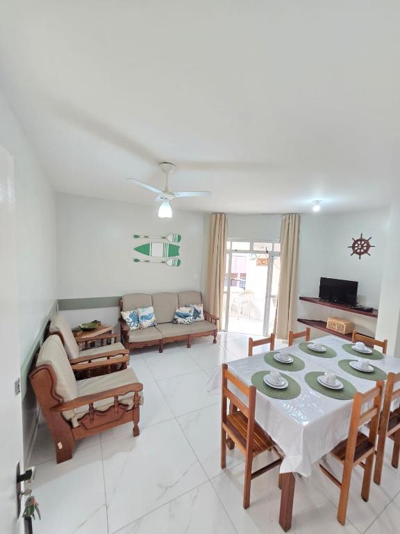 a living room with a table and a couch at Praia Morro Katia apartamentos - Edificio Porto Belo in Guarapari