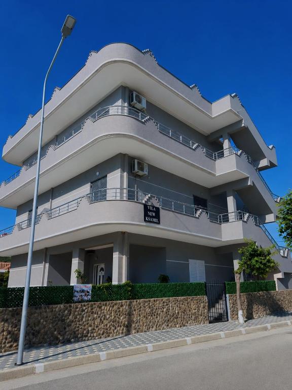 a white building with balconies and a street light at Vila New Ksamil in Ksamil