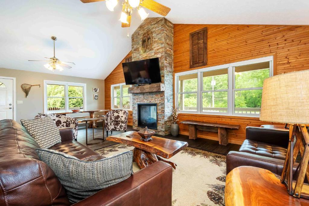a living room with leather furniture and a stone fireplace at Light My Fire in McHenry