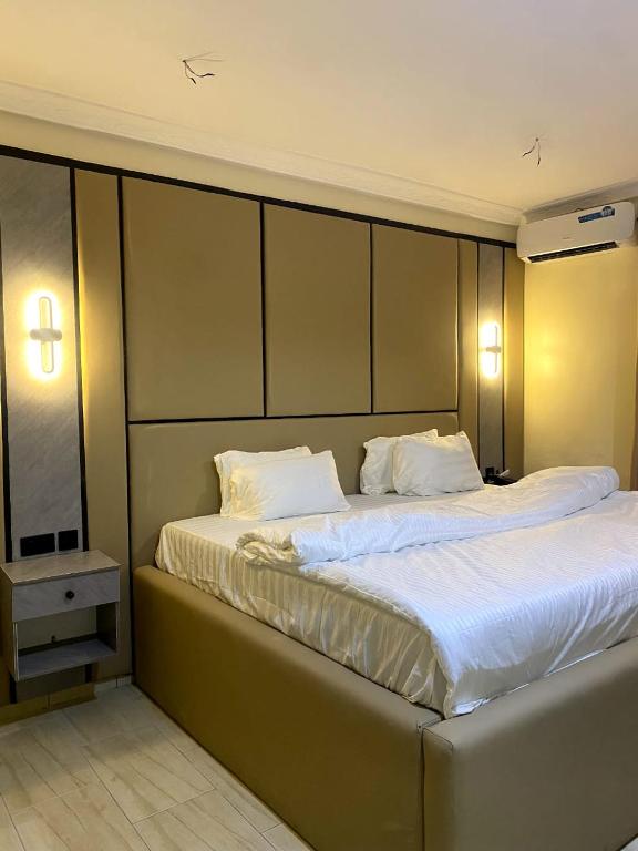 a bedroom with a large bed with white sheets at D' Amex Hotel in Lekki