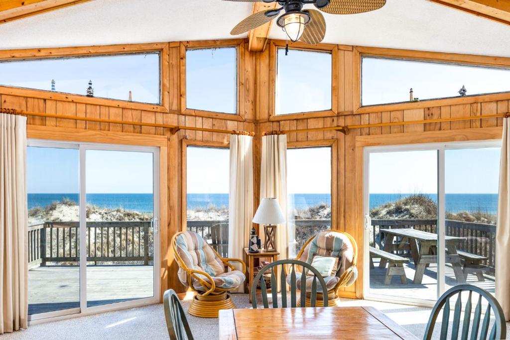 a dining room with a view of the ocean at 1227 - Seven Shells in Corolla