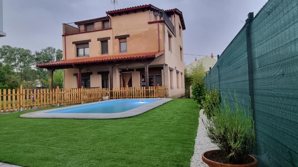 a house with a swimming pool in front of a house at Casa vacacional El Arroyo in Ferreras de Arriba