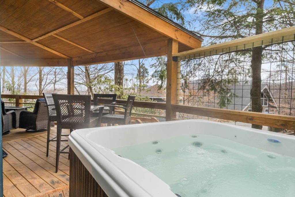 a hot tub on a deck with a table and chairs at Round House in Beech Mountain