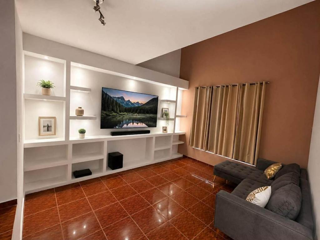 a living room with a couch and a flat screen tv at Casa ejecutiva para 10 personas in Gómez