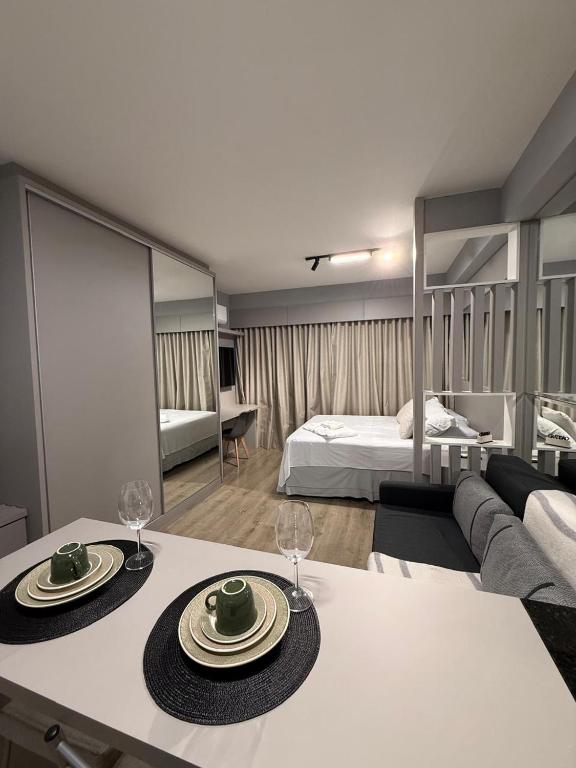 a living room with a table with two plates on it at Studio Lifespace Batel Torre A in Curitiba