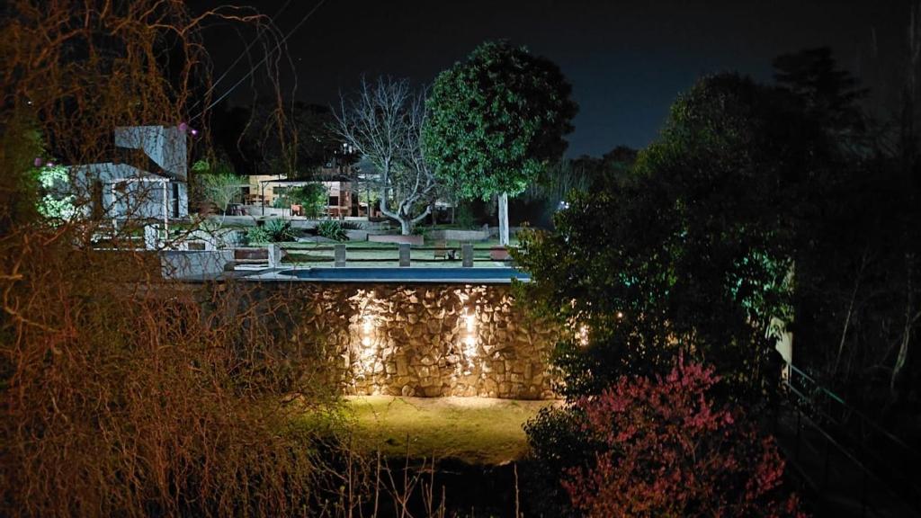 a garden at night with a pond and a bench at Rio Cabañas in Huerta Grande