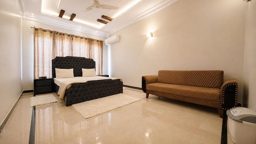 a bedroom with a bed and a couch at Divon B&B in Islamabad