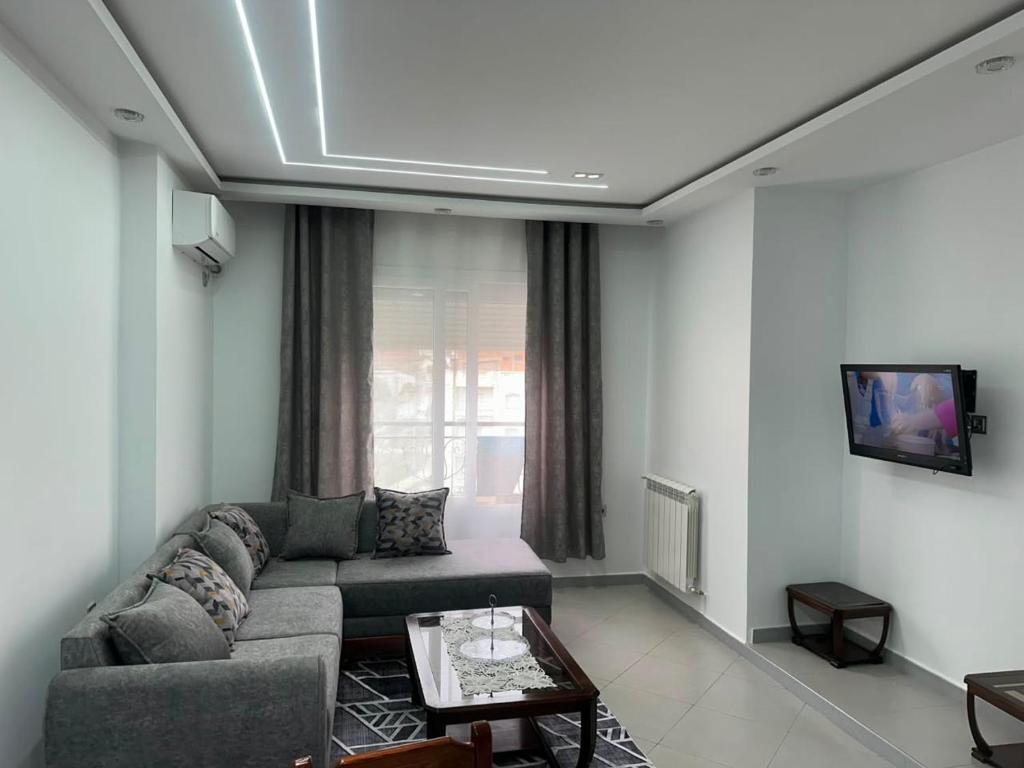 a living room with a couch and a tv at Appartement in Jijel