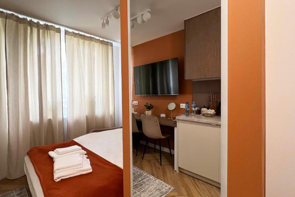 a room with a bed and a kitchen with a table at Velvet Studio in Zamość