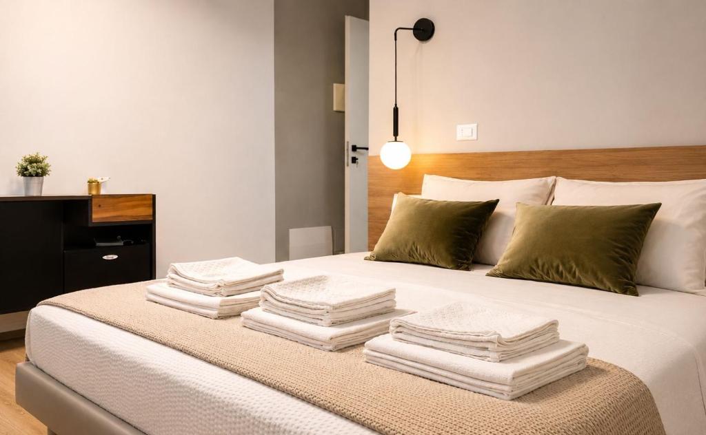 a white bed with towels stacked on top of it at A Due Passi Dalla Scalinata Rooms in Caltagirone