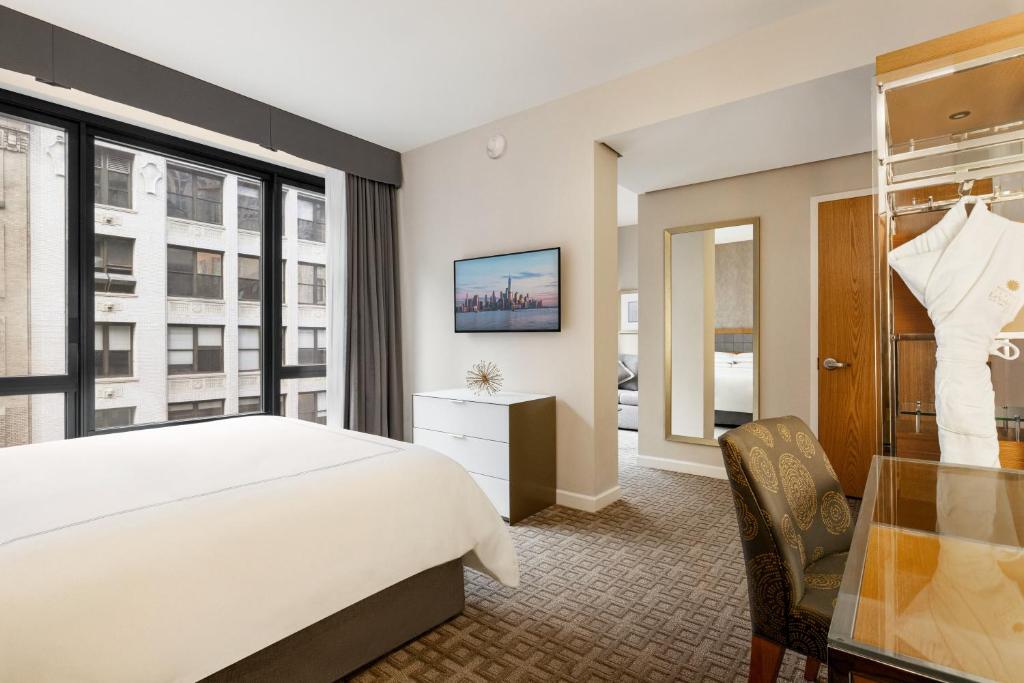 una camera da letto con un letto, una scrivania e una finestra di Executive Hotel Le Soleil New York a New York