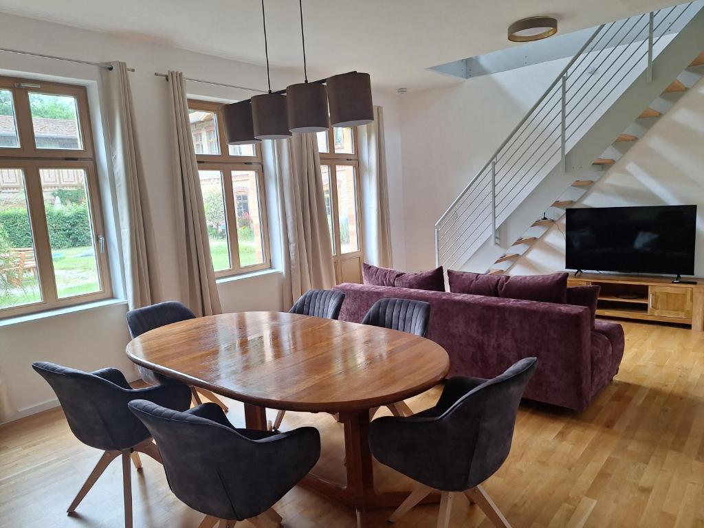a living room with a table and a couch at Logierhaus Hoppegarten direkt an der Rennbahn mit perfekter S-Bahn Anbindung in Hoppegarten