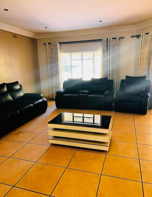 a living room with a couch and a coffee table at The Vine House in Harare