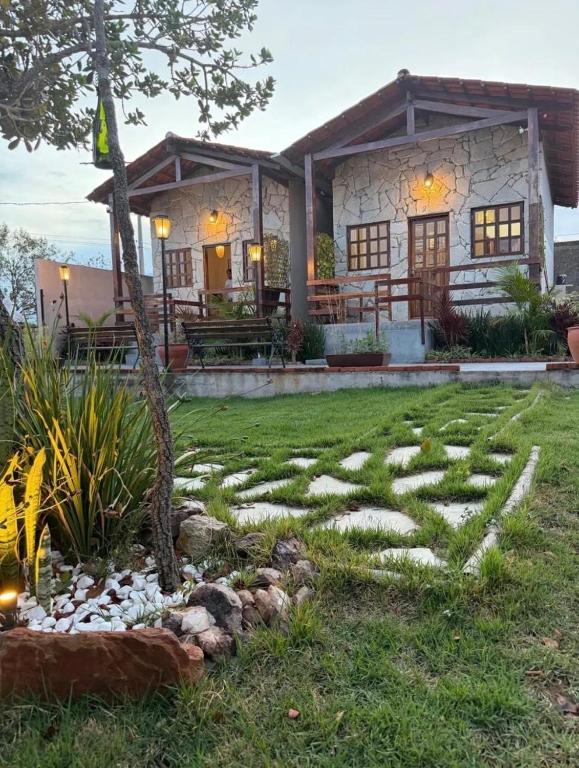 a house with a stone path in the yard at Vila Maytrea Chalés in Alto Paraíso de Goiás