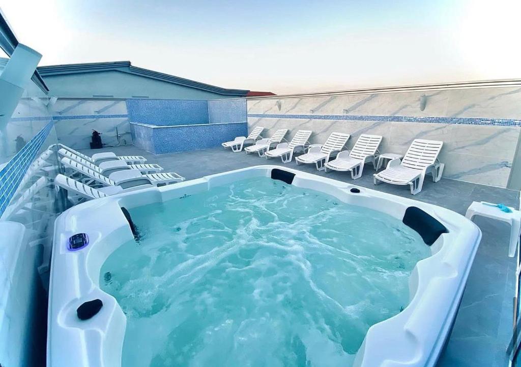 a large hot tub on a patio with lounge chairs at Eki 2026 VIP in Donji Štoj