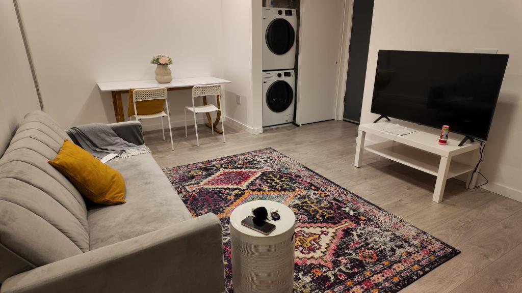 a living room with a couch and a flat screen tv at Cozy 1 bed and 1 bath in Surrey