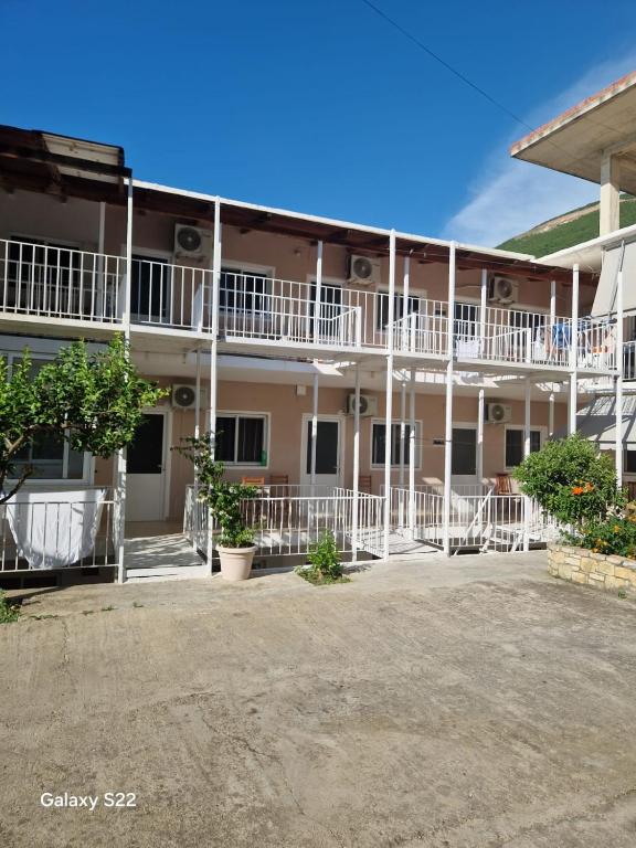 a building with white balconies and trees in the courtyard at Sunset Panorama Residence in Vlorë