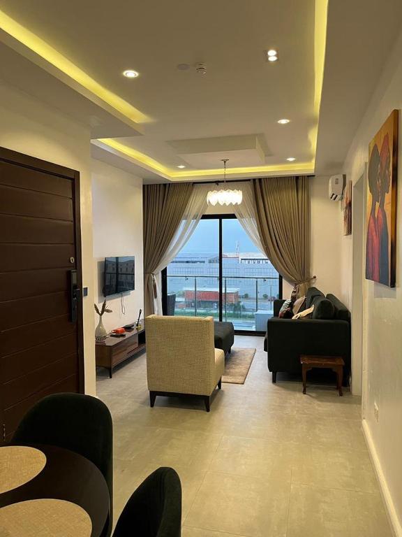 a living room with a couch and chairs and a window at Pcg Homes in Lagos
