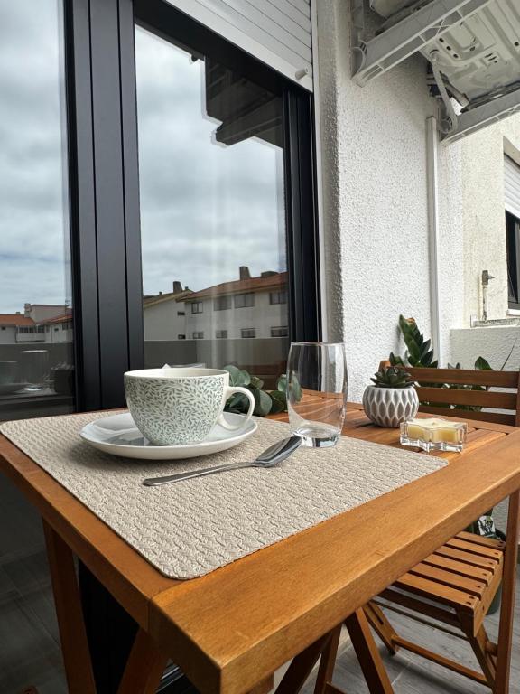 a table with a bowl and a cup and a glass at Refúgio da Barra in Gafanha da Nazaré