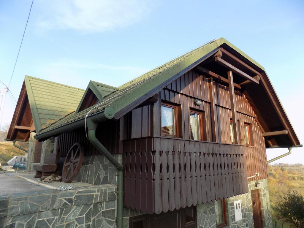 una pequeña casa de madera con techo verde en Apartment Zeleni dragulj Pohorje, en Oplotnica