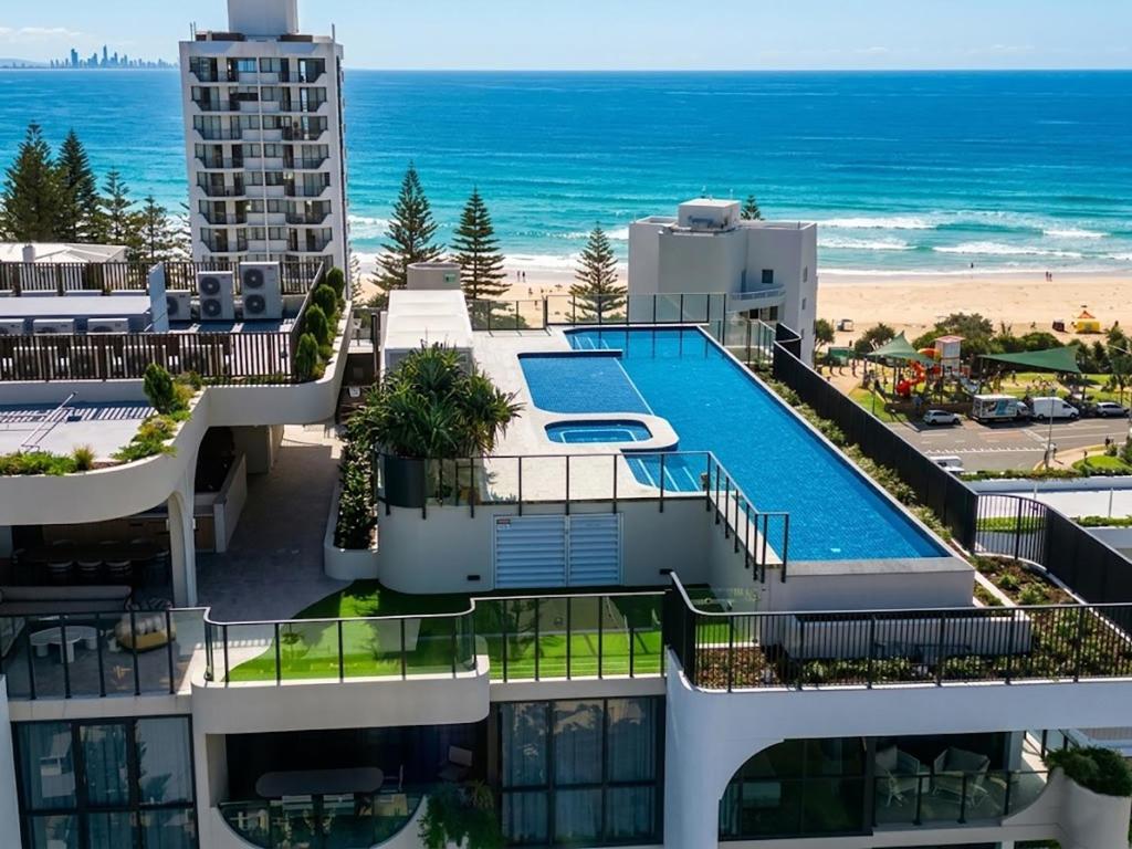 an aerial view of a building with a swimming pool and the beach at Luxury Esprit Apartment at Rainbow Bay in Gold Coast