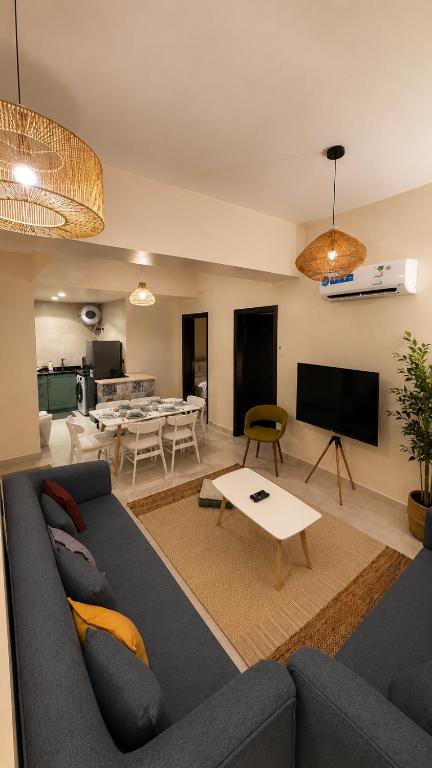 a living room with a blue couch and a table at غرفتين وصالة شقق ديما الفندقية in Abha