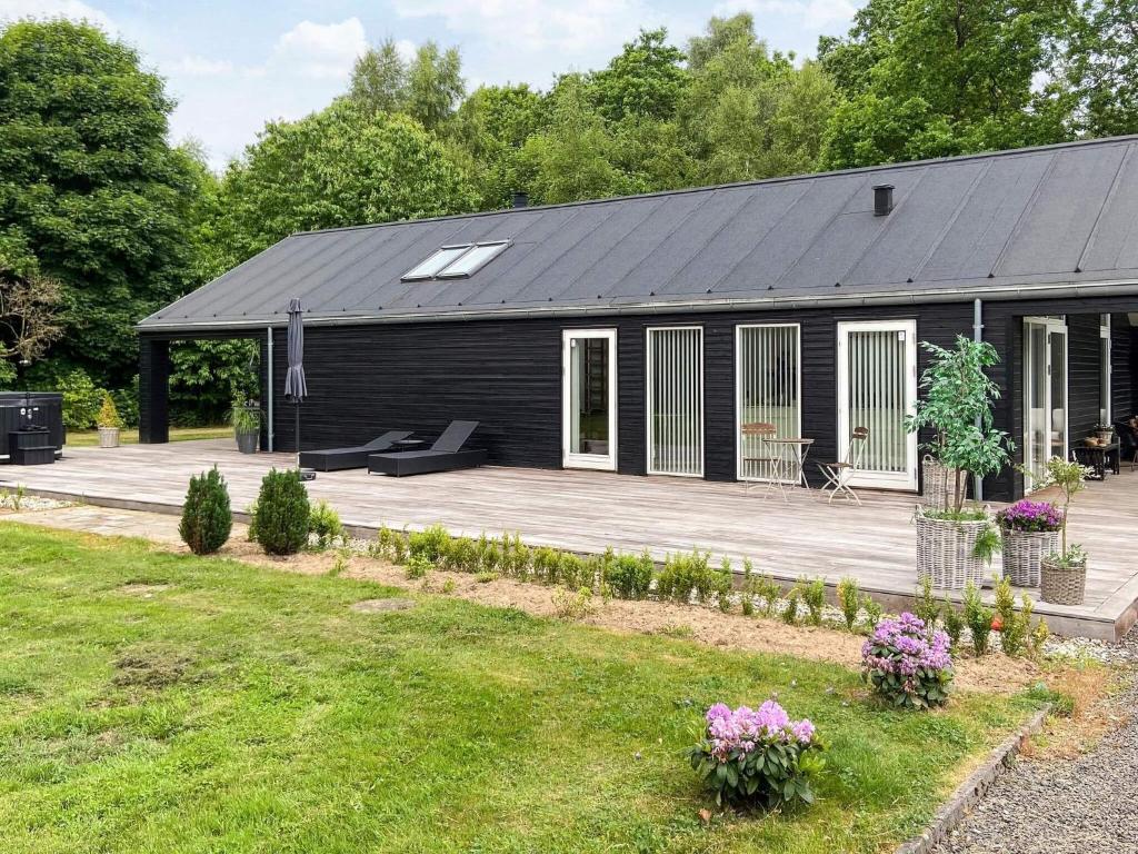 a black building with a deck and a house at 4 star holiday home in Skals-By Traum in Skals