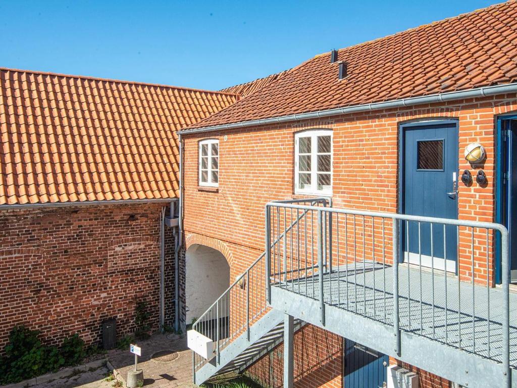 a brick building with a blue door and a staircase at Holiday home in Ringkobing in Ringkøbing