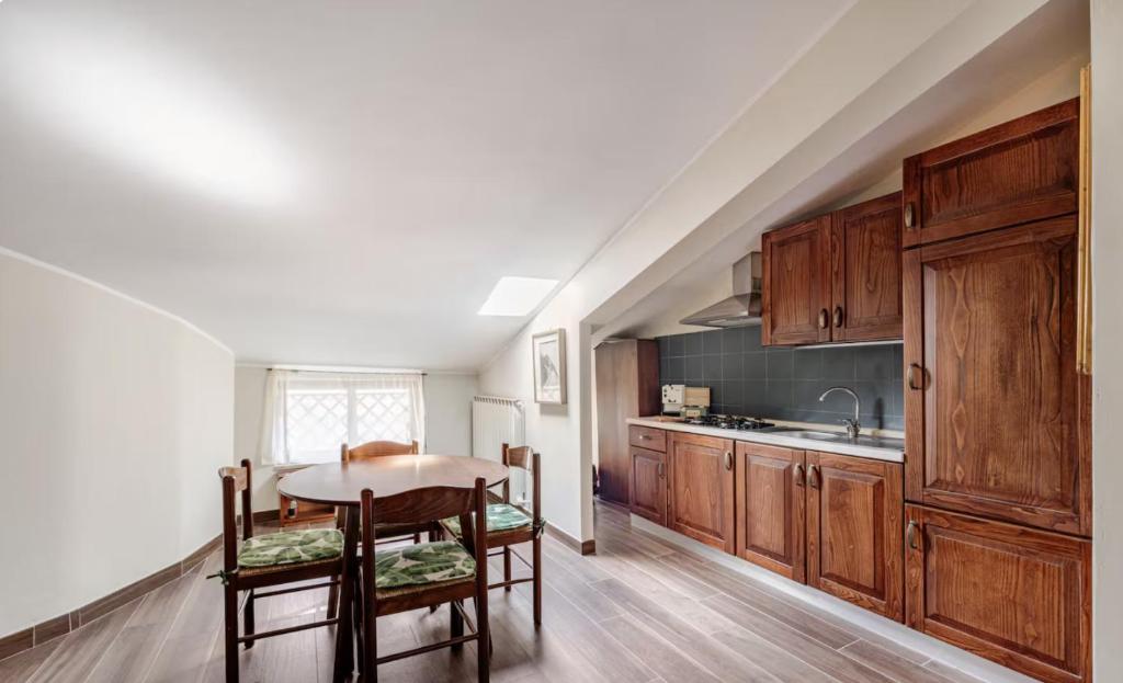 a kitchen with wooden cabinets and a table and chairs at Central Lux - Casa Caracciolo in Castel di Sangro