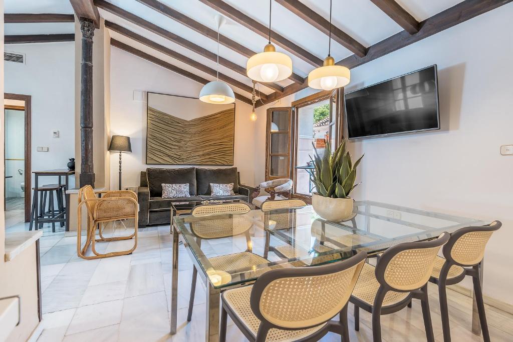 a living room with a glass table and chairs at BnS Dauro Suites in Granada